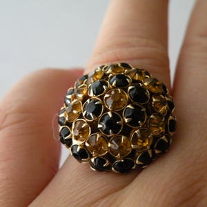 Zwarte, donkergele koepelring met strassteentjes. Verstelbaar.