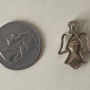 May include: Silver angel pendant charm with a hallmark that reads "AU .925" on the back.