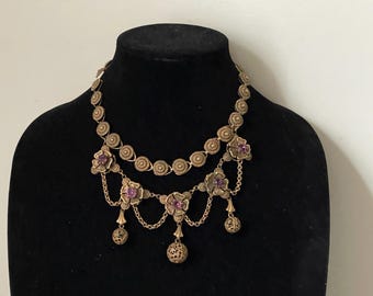 May include: A gold-tone necklace with a double row of round links and dangling floral accents with purple gemstones.