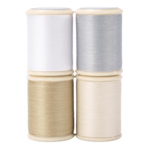 May include: Four spools of thread in white, silver, beige, and cream colors. The spools are cylindrical with a light beige base and top. The thread is tightly wound, suggesting a high-quality sewing material.