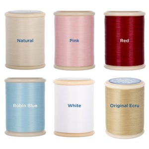 May include: Six spools of thread in various colors: natural, pink, red, robin blue, white, and original ecru. Each spool is cylindrical with a light-colored top and bottom. The color names are printed on each spool.