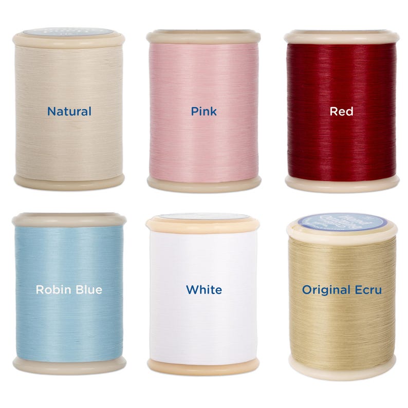 May include: Six spools of thread in various colors: natural, pink, red, robin blue, white, and original ecru. Each spool is cylindrical with a light-colored top and bottom. The color names are printed on each spool.