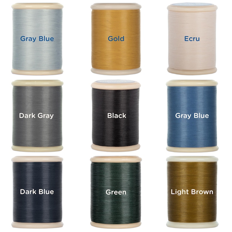 May include: Nine spools of thread in various colors, including gray blue, gold, ecru, dark gray, black, dark blue, green, and light brown. Each spool has a label with the thread color name.