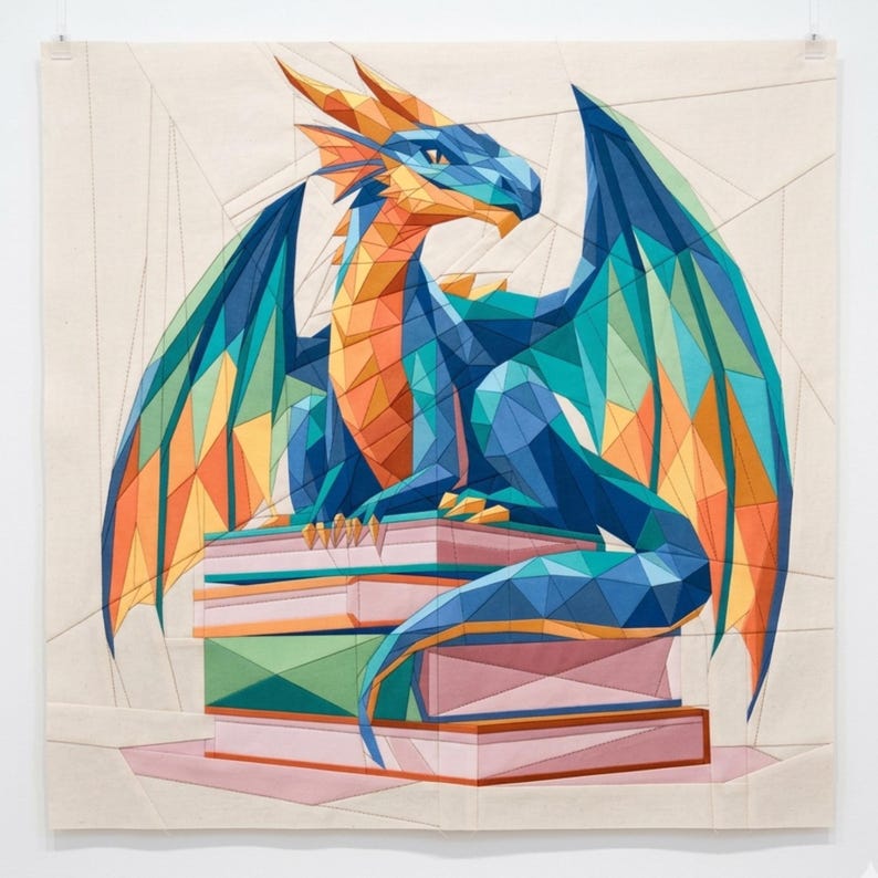May include: A fabric wall hanging featuring a geometric, low-poly style dragon in shades of blue, orange, and teal. The dragon is perched atop a stack of books rendered in muted pink and green tones, all set against a plain, light-colored background.