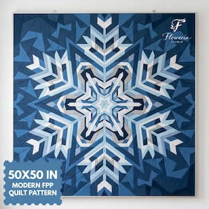 May include: A square quilt featuring a geometric snowflake pattern in shades of navy, royal blue, light blue, and white. The text Floweria Studio is in the top right corner. The text 50x50 IN MODERN FPP QUILT PATTERN is in the bottom left corner.