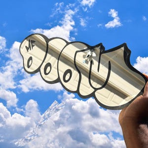 May include: A mirror with the word "WOW" in a graffiti style, held against a blue sky with clouds. The mirror's outline is black, and the letters are a cream color. The letters "MF" are in the upper left corner.