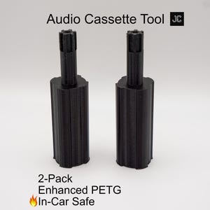 May include: Two black audio cassette tools are displayed against a white background. The tools have a cylindrical body with a textured top. Text at the top reads "Audio Cassette Tool". Below, the text says "2-Pack Enhanced PETG In-Car Safe".