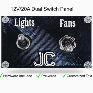 May include: A black dual switch panel with the text "Lights" and "Fans" in white. The panel includes two toggle switches and the initials "JC". The panel is secured with four screws and includes the text "Hardware Included", "Pre-wired", and "Customized Text".