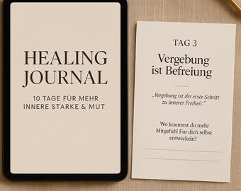 May include: A black-framed journal with the words "HEALING JOURNAL" and "10 TAGE FÜR MEHR INNERE STARKE & MUT" printed on the cover. Beside it, a card reads "TAG 3 Vergebung ist Befreiung" with additional text in German.