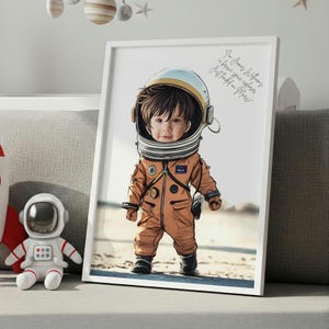 May include: Framed artwork featuring a child in an orange astronaut suit and helmet. The child is standing on a sandy surface. The artwork includes the text: "I'm James Williams, a brave space explorer, just landed on Mars!"