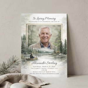 May include: A funeral memorial card featuring a portrait of an older man in a gold frame, set against a watercolor landscape of a lake, forest, and a person fishing in a boat. Text reads In Loving Memory, Alexander Sterling, and event details.