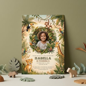May include: A birthday invitation with a jungle theme, showcasing a child's photo amidst tropical plants and animals. The invitation reads "ISABELLA IS TURNING 4" with event details. Wooden animal decorations are in the foreground.