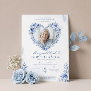 May include: A funeral program card featuring a central heart-shaped frame of blue watercolor roses surrounding a portrait of a woman. The text reads Margaret Elizabeth Williams, dates, and service details in blue font on a white background.