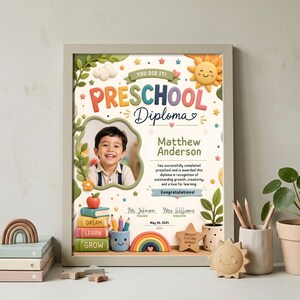 May include: A framed preschool diploma featuring a photo of a smiling child. The diploma includes the text "Preschool Diploma," the child's name, and the date. Decorative elements include a sun, clouds, stars, and a rainbow.
