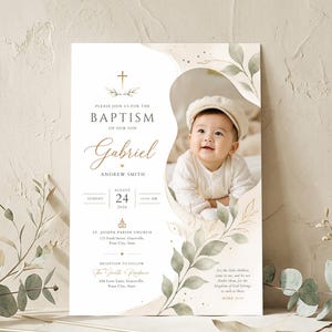 May include: A baptism invitation card featuring a gold cross, green watercolour leaves, and a photo of a baby in a cream cap. The text includes the name Gabriel Andrew Smith, the date August 24, 2026, and church details in a clean, elegant layout.