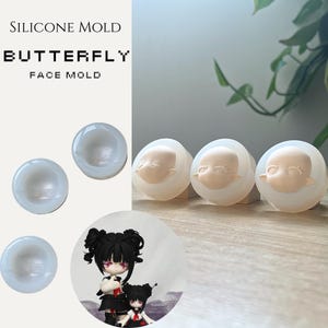 May include: Silicone mould for crafting, featuring a butterfly face design. The image shows several clear, round moulds with a face impression, along with a finished doll figure. Text on the image reads "SILICONE MOLD BUTTERFLY FACE MOLD."