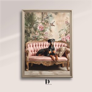 May include: A framed artwork featuring a Doberman Pinscher resting on a pink, ornate sofa. The background showcases a floral and botanical design with birds. The sofa has gold accents and a patterned pillow.