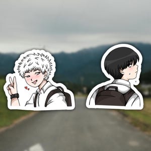 May include: Two anime-style stickers featuring male characters. One has white spiky hair, a peace sign, and hearts. The other has black hair and a backpack. Both wear white shirts and backpacks. The background is a blurred outdoor scene.