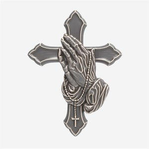 May include: A gray cross with praying hands and a rosary. The hands are clasped in prayer and are draped with a beaded rosary. The cross has a decorative edge and a small cross at the bottom.