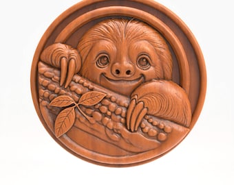May include: A round, wooden carving of a smiling sloth clinging to a branch. The sloth has detailed fur and is surrounded by a circular frame. The carving is a warm brown color and features a leaf and textured details.