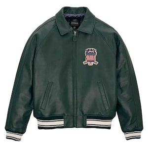 May include: Dark green leather jacket with a zip-up front, collar, and ribbed cuffs and hem with white stripes. Features a patch on the chest with the text "AVIREX" and a patriotic design.