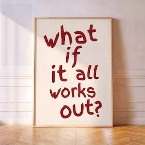 Könnte beinhalten: Ein rechteckiger Wandkunstdruck in einem hellen Holzrahmen mit dem dunkelroten Text "what if it all works out?" in einem lässigen, handgeschriebenen Pinselstrich-Stil auf einem schlichten, cremeweißen Hintergrund.