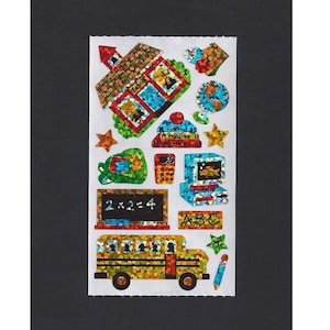 May include: A sheet of colorful, glittery stickers featuring school-themed images, including a school bus, a schoolhouse, a globe, a pencil, a star, a calculator, a computer, a book stack, a chalkboard with the equation 2x2=4, and the letters ABC.