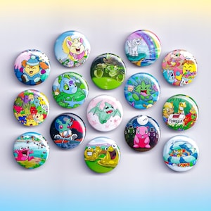 May include: A collection of colorful, round button pins with various cartoon character designs. The pins feature images of mythical creatures, animals, and whimsical scenes, with a glossy finish. The pins are arranged on a white surface.