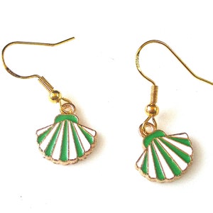 May include: A pair of gold earrings with green and white seashell charms. The seashells have a white background with green stripes.