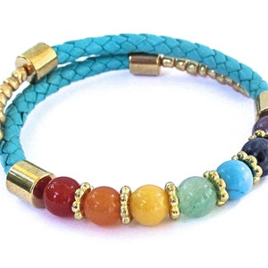 May include: A turquoise leather bracelet with gold beads and seven colorful gemstone beads. The bracelet is wrapped twice around the wrist.