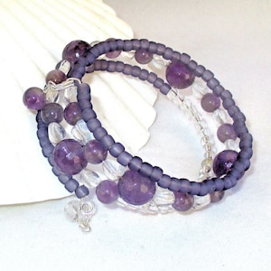 May include: A multi-strand bracelet with amethyst and clear glass beads. The bracelet is made with a wire wrap closure.
