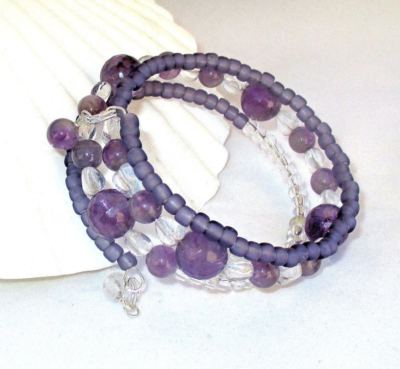 May include: A multi-strand bracelet with amethyst and clear glass beads. The bracelet is made with a wire wrap closure.