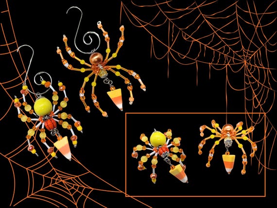 Tiny hand-beaded spiders in Halloween candy-corn colorways — absurdly charming seasonal folk art that looks like it escaped a very stylish witch's cabinet.