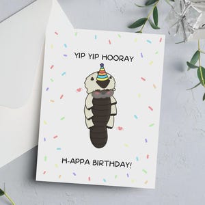 以下が含まれることがあります： パーティーハットをかぶった漫画のAppaキャラクターが描かれたバースデーカード。カードには「Yip Yip Hooray」と「H-Appa Birthday！」の文字とカラフルな紙吹雪が描かれています。封筒が見えます。