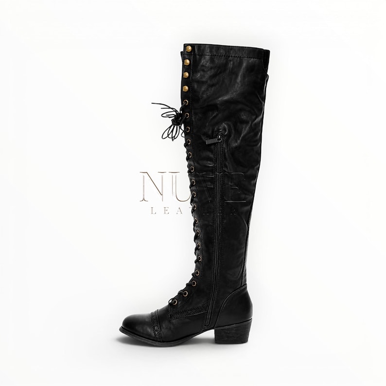 May include: Black leather knee-high boot with lace-up front and side zipper. The boot features a small heel and decorative gold-colored studs near the top. The brand name "NU LEATHER" is visible in the image.