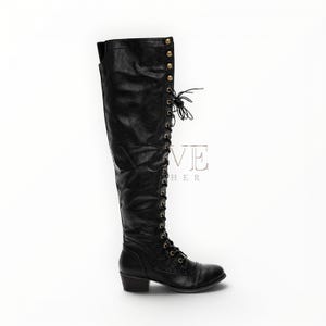 May include: Black leather knee-high boot with a lace-up design and small heel. The boot features gold-colored button details along the top and a rounded toe. The boot is shown against a white background.