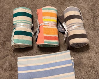 Toalla de playa a rayas de sol y arena