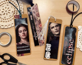 May include: Handmade bookmarks featuring images from "The Twilight Saga: Eclipse." The bookmarks are rectangular with images of characters and the movie title. One bookmark has the text "IT ALL BEGINS... WITH A CHOICE." Each bookmark has a tassel or ribbon.
