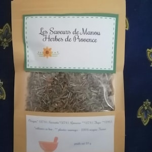 Könnte beinhalten: Ein Kraftpapierbeutel gefüllt mit getrockneten Kräutern, beschriftet mit "Les Saveurs de Manou Herbes de Provence". Das Etikett enthält ein Blumendesign und die prozentualen Anteile der Zutaten. Der Beutel enthält 10 g Kräuter.