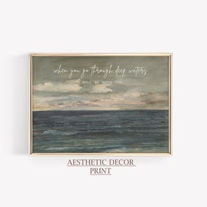 May include: A framed print featuring an ocean scene with a cloudy sky. The artwork has a vintage aesthetic, with the text "when you go through deep waters, I will be with you" in a script font. The words "Aesthetic Decor Print" are at the bottom.