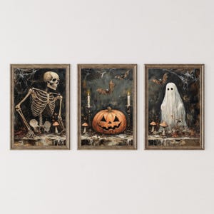 May include: A set of three framed Halloween art prints. The prints depict a skeleton, a carved pumpkin with bats, and a ghost. Each print has a dark colour palette with brown wooden frames, creating a spooky atmosphere.