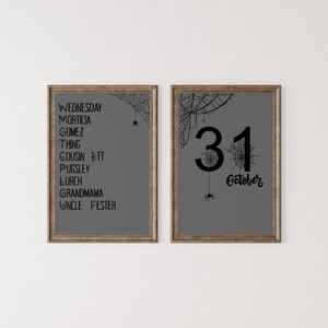 May include: Two framed Halloween prints. The left print lists names including Wednesday, Morticia, and Gomez. The right print shows the number 31 and the word "October". Both prints have a grey background, spiderwebs, and spiders.