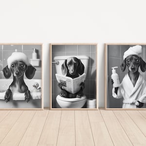 Pode incluir: Conjunto de três impressões emolduradas em preto e branco com dachshunds em cenas de banheiro humorísticas. Um cão está em uma banheira com bolhas, outro em um vaso sanitário lendo um jornal e o terceiro em um roupão.