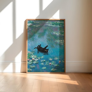May include: A framed art print depicting a black cat in a pond with lily pads, reminiscent of Monet's water lilies. The artwork is in a wooden frame and displayed on a wooden floor.