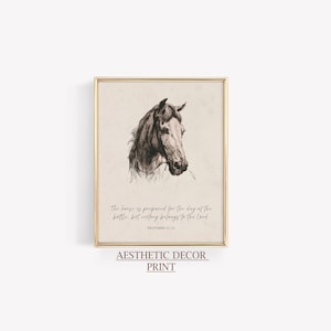 May include: A framed print featuring a detailed black and white illustration of a horse's head. The print includes the text "The horse is prepared for the day of the battle, but victory belongs to the Lord. Proverbs 21:31" and "Aesthetic Decor Print."