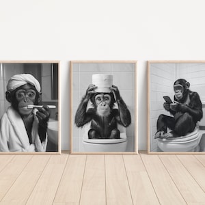 May include: Set of three framed black and white prints featuring chimpanzees in humorous bathroom scenes. One brushes its teeth, another balances toilet paper on its head, and the third uses a smartphone while seated on a toilet.