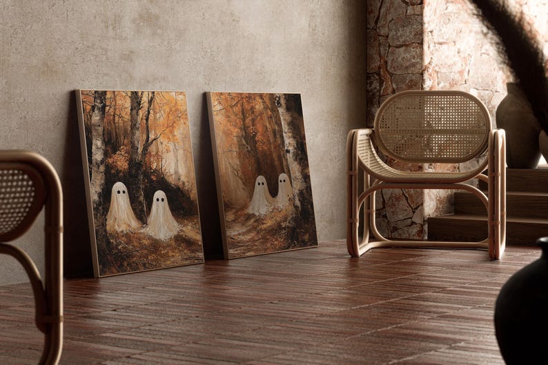 Op de afbeelding: Twee ingelijste canvas prints met een bossc&egrave;ne met spookfiguren. Het kunstwerk gebruikt een warm kleurenpalet van bruin en oranje, met een houten stoel op de achtergrond. De kunst leunt tegen een neutrale muur.