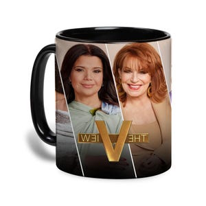 以下が含まれることがあります： 黒いセラミックマグカップ。顔のコラージュと、スタイリッシュなフォントで「THE VIEW」という金の文字が特徴です。マグカップは黒いハンドルと内側を持ち、顔は女性です。