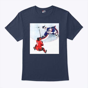 May include: Navy blue t-shirt featuring a hockey-themed graphic. The graphic depicts two hockey players in action on the ice, one in red and the other in blue. The image is a dynamic illustration of a hockey game.