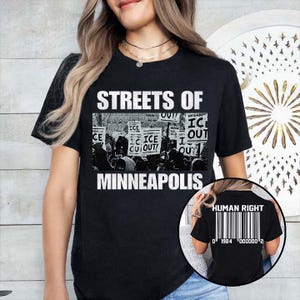 May include: Black t-shirt with the text "STREETS OF MINNEAPOLIS" above a black and white image of a protest. The back of the shirt has the words "HUMAN RIGHT" above a barcode and the numbers "0 1984 000000 2".